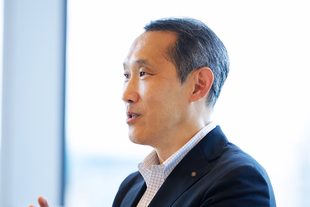 Profile view of Mr. Takaoka speaking