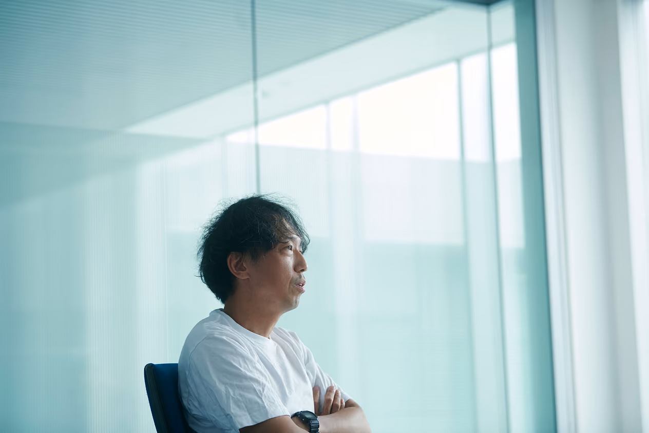 Kenta Jonai speaking with his arms crossed in a conference room