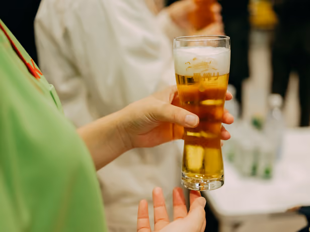 A hand holding a glass of KIRIN ICHIBAN