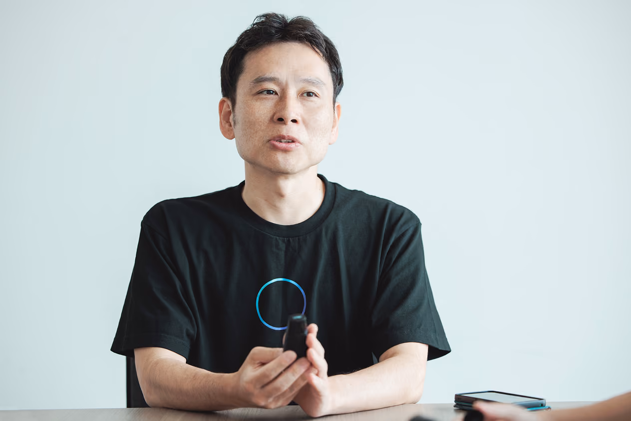 Yuji Kaneko holding Lumen while conversing