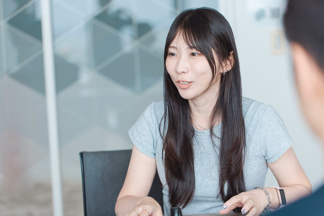Yan Shin conversing while seated in an office chair